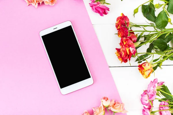 Smartphone, roses on the table. Women\'s things Fashion womens desk Top view Mockup