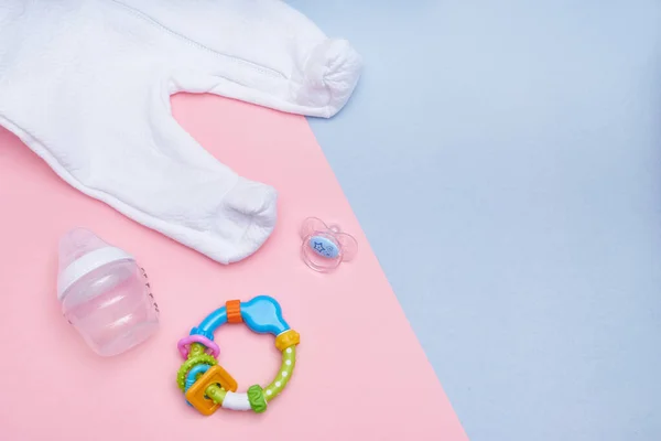 Baby accessories on pink and blue background. Flat lay . Top view Copy space