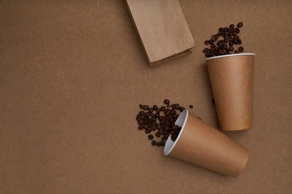 Two craft glasses with package and coffee beans on craft background . Monochrome photo