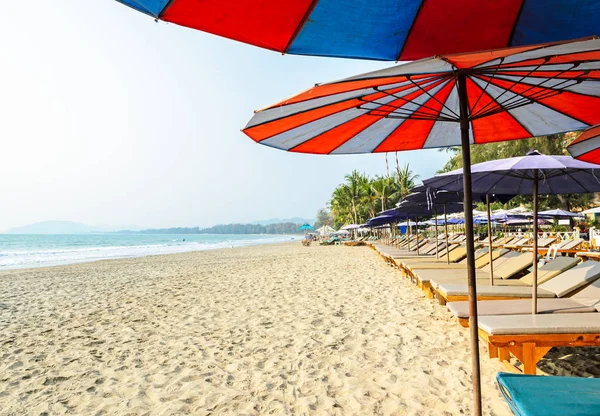 タイで傘を持つ熱帯の砂浜のビーチでのサンベッドの行 — ストック写真