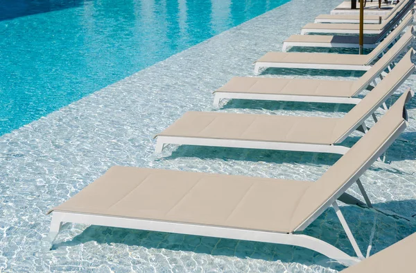 Swimming pool with chaise loungers — Stock Photo, Image