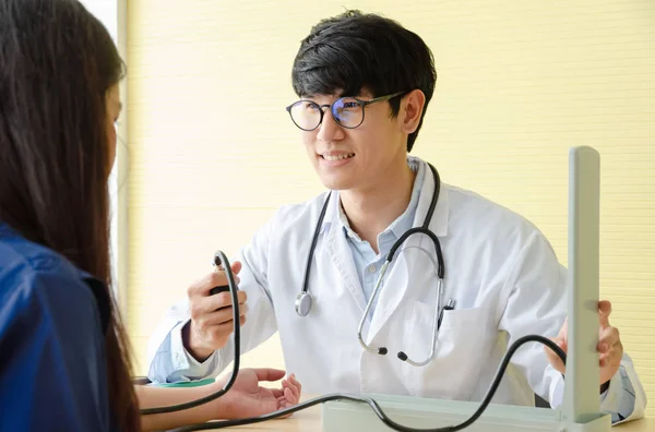 Lekarz sprawdzanie kobiet ciśnienie krwi pacjenta w gabinecie lekarskiej — Zdjęcie stockowe