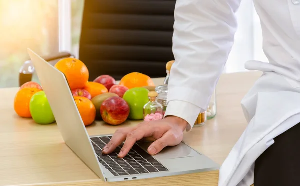 Medico Nutrizionista Camice Bianco Lavoro Seduto Sulla Scrivania Legno Digitando Fotografia Stock