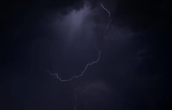 fırtına ve şimşek uyuyan bir şehir üzerinde bir yaz gecesi