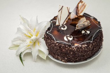 hafif bir arka plan üzerinde toz ile ARGE beyaz zambak ve çikolata kek