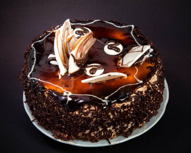 küçük çikolata kek frosting ve beyaz siyah bir arka plan üzerine çikolata süslemeleri