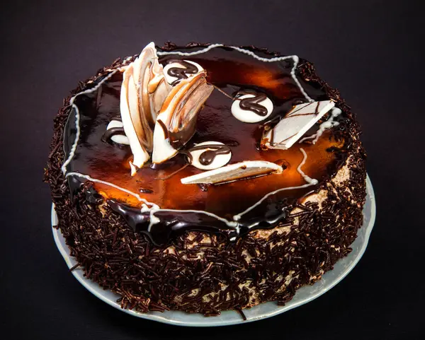 küçük çikolata kek frosting ve beyaz siyah bir arka plan üzerine çikolata süslemeleri