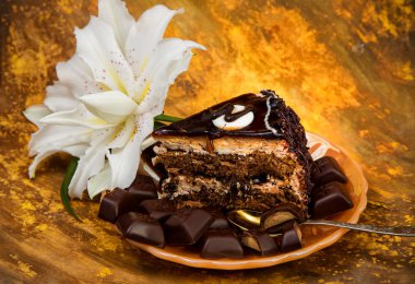 sarı inci tabakta çikolatalı kek Çikolata fayans mermer sarı bir arka plan ve lily çiçek adet kesilmiş bir parçası