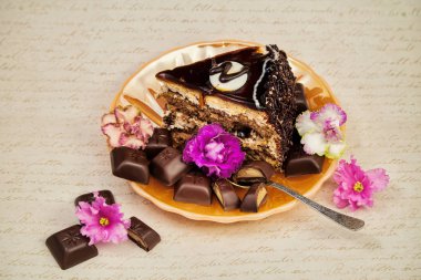 menekşe retro bir zemin üzerine çikolata kiremit parçaları ile sarı inci tabakta parça çikolatalı pasta kesme