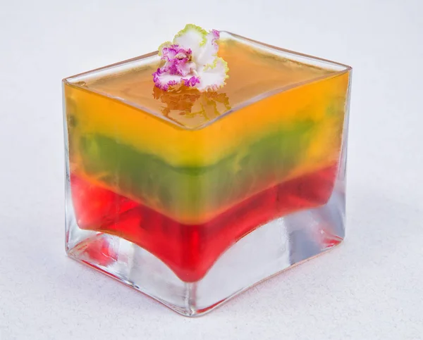 tricolor jelly in a square glass mold on a white background