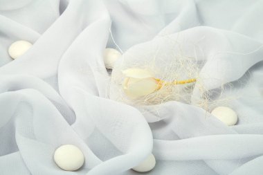 yumuşak kumaş kıvrımları ile bahar beyaz frezya ve yuvarlak şekerleme kaplı beyaz arka plan