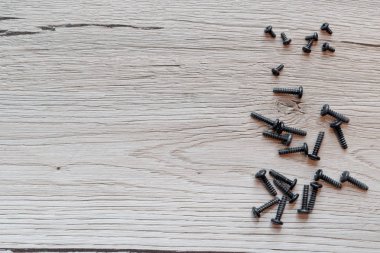 Küçük siyah vida ahşap arka plan üzerinde sağ tarafta koyulur