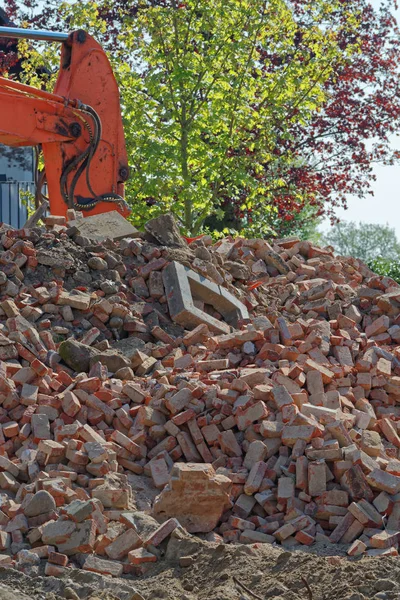 Eski tuğla ve turuncu Hidrolik buldozer Ekskavatör kol arka planda Stapelfeld, Almanya yığın
