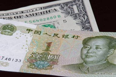 Bir Amerikan Doları siyah arka plan üzerine bir Çin yuan banknot üzerindedir