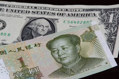 Bir Amerikan Doları siyah arka plan üzerine bir Çin yuan banknot üzerindedir