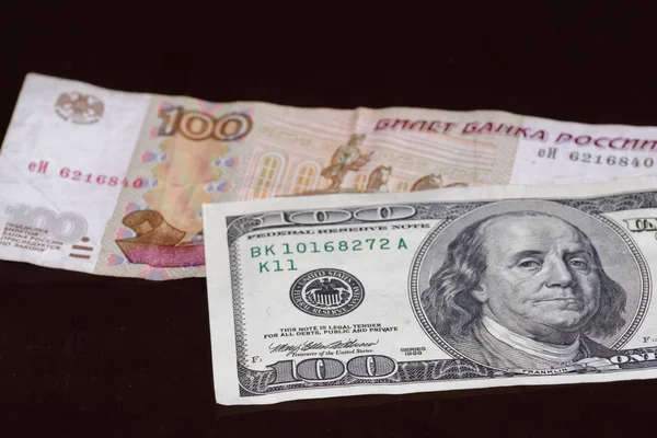 Rus yüz ruble siyah arka plan üzerine 100 Amerikan Doları banknot üzerindedir