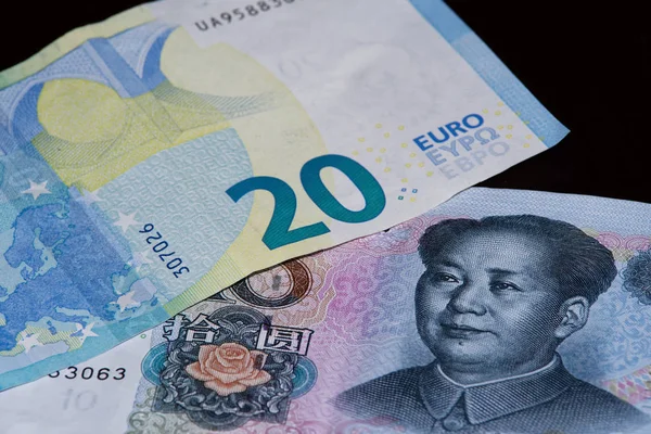 Siyah arka plan üzerine on Çin yuan 20 euro banknot üzerindedir