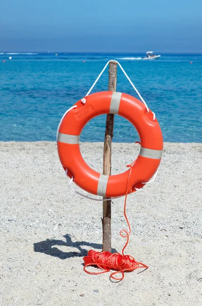 Mavi deniz suyuna karşı kum plajındaki turuncu yaşam şamandıra. Riaci sahil yakınında Tropea, İtalya