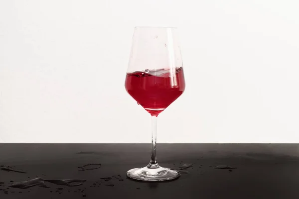 红葡萄酒在黑暗的桌子和白色的背景的杯子运动 — 图库照片