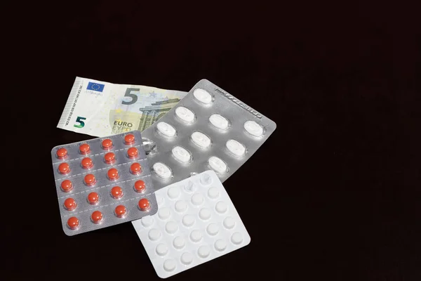 つのブリスター パッケージと薬 そして暗い背景に ユーロ紙幣 — ストック写真