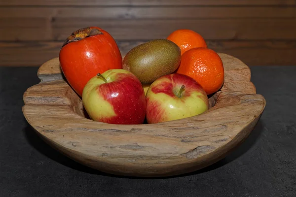 Różne owoce w drewnianej misce — Zdjęcie stockowe