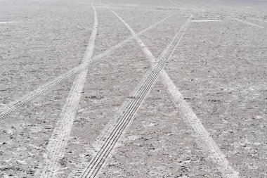 Bir arabanın kumdaki tekerlekleri.