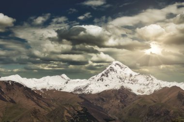 Güzel dağ manzarası. Kazbek Dağı üzerinde gün batımı, townlet Stepantsminda, Gürcistan.