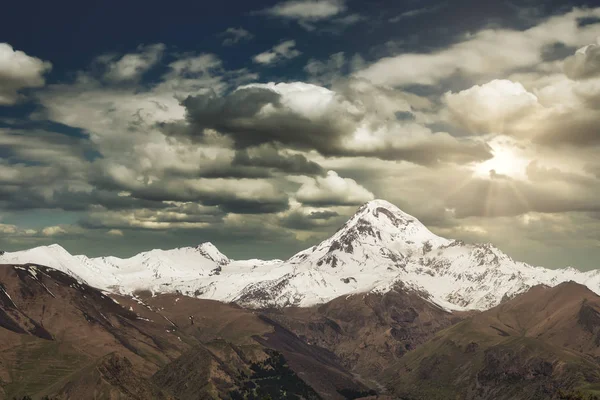 Nádherná horská krajina. Západ slunce nad Mount Kazbek, městečkem Stepantsminda, Gruzie. — Stock fotografie