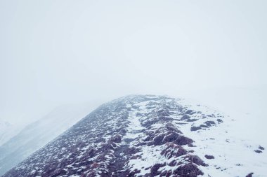 Dağlarda mistik kar izleri. Karların altında çimenleri silkeledik ve beyaz kalın sis.