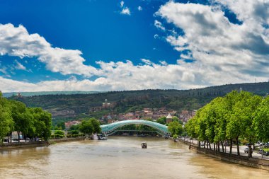 Tiflis - 9 Mayıs 2017. Georgia 'nın başkenti Kura Nehri üzerindeki Barış Köprüsü. Güneşli bir gün, bulutlu mavi bir gökyüzü.