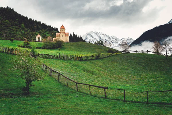 Église orthodoxe géorgienne dans les montagnes du Caucase. Ciel nuageux, brouillard, herbe verte . — Photo