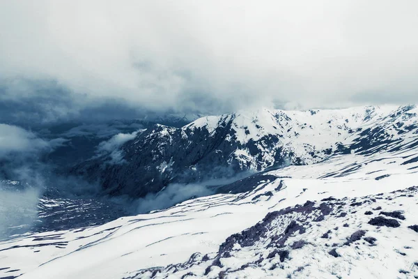 Mystiska snöiga berg i dimman. Royaltyfria Stockbilder