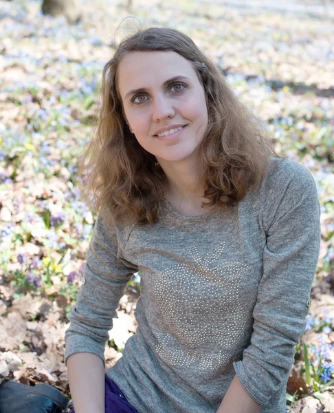 Mädchen Riecht Blumen Während Sie Auf Der Grünen Wiese Sitzt — Stockfoto