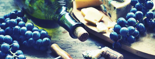 一瓶葡萄酒 葡萄和软木塞与奶酪在木桌上 — 图库照片
