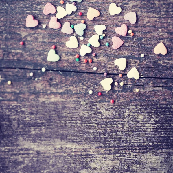 Colorful romantic hearts on wooden background