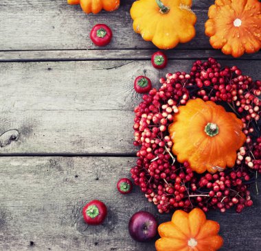 kabaklar ve ahşap masa üzerinde kırmızı meyveler ile arka plan