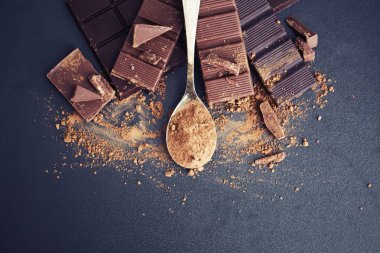 Gri zemin üzerine kaşıkla kırık çikolata