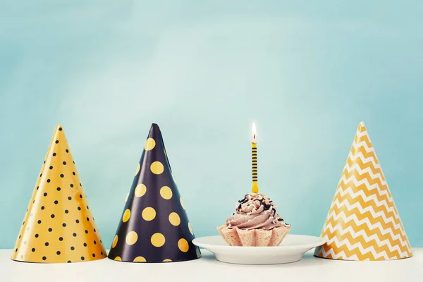 Birthday cake with candle and cone hats in vintage style, copy space
