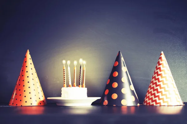 Birthday cake with candles and cone hats in vintage color, copy space