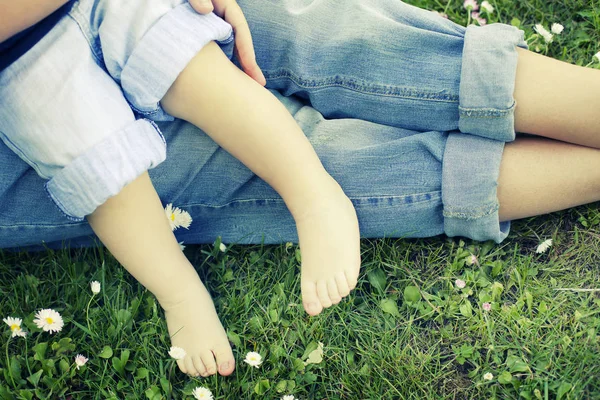 Barefooted people on green grass with white flowers