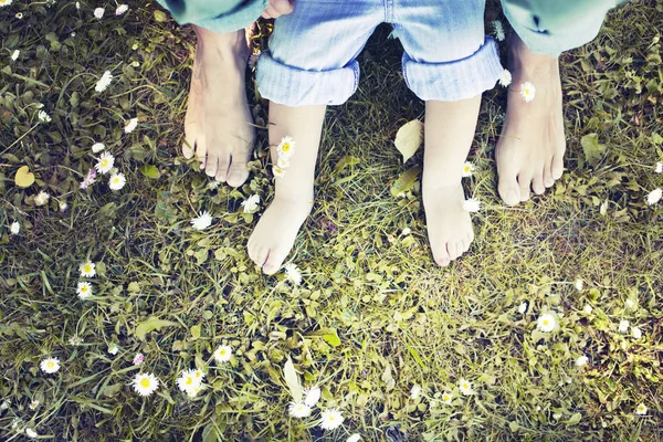 low section view of mother and son feet on grass