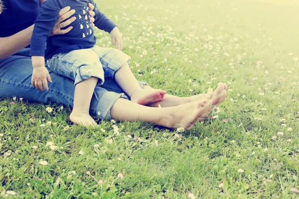 芝生の上の母と息子の足低断面図 — ストック写真