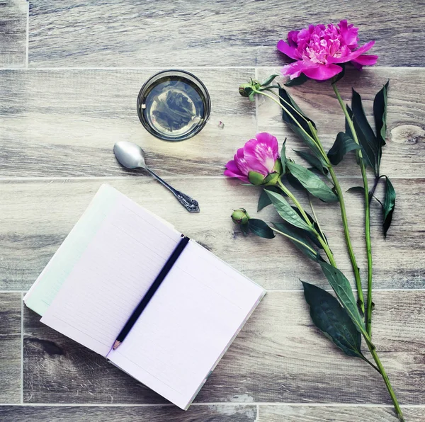 花と木のテーブルの上のノートで居心地の良い組成の平面図 — ストック写真