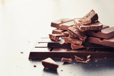 Gri arka plan üzerinde çikolata kırık apetisant