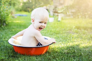 Havza yaz çayır üzerinde oynarken mutlu yürümeye başlayan çocuk Bahçe çim