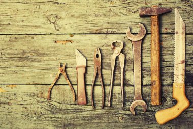 ahşap bir masa üzerinde eski paslı el araçlar kümesi