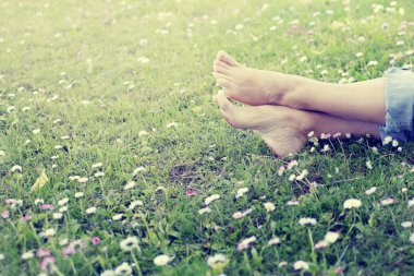 Ayaklarda papatya çiçekler ile çayır çim