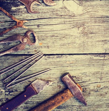 ahşap bir masa üzerinde eski paslı el araçlar kümesi