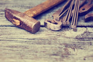 ahşap bir masa üzerinde eski paslı el araçlar kümesi