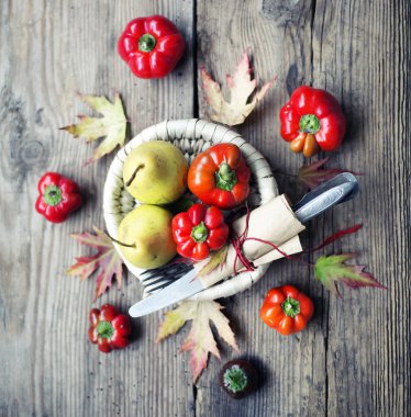 Tabak ve çatal bıçak takımı ahşap arka plan üzerinde renkli biber